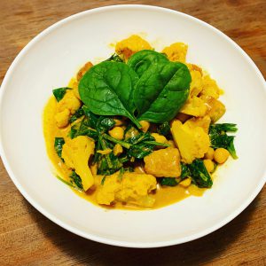 Gele curry met gebakken tempeh, spinazie, bloemkool en kikkererwten